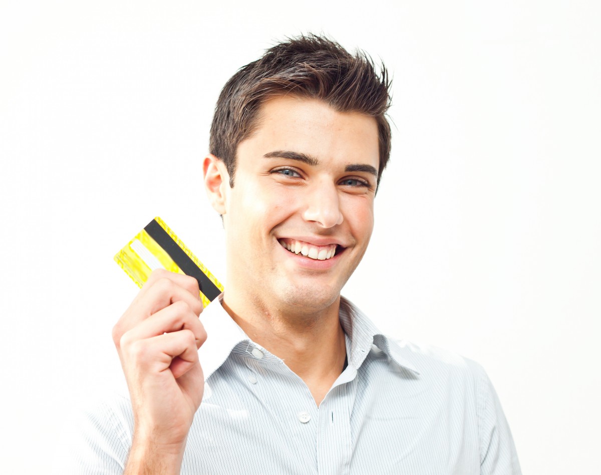 Young man happy holding credit card